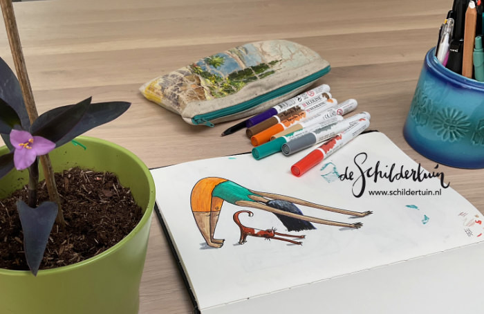 foto van tekening met vrouw en kat die samen yoga doen, tekenmaterialen en plant